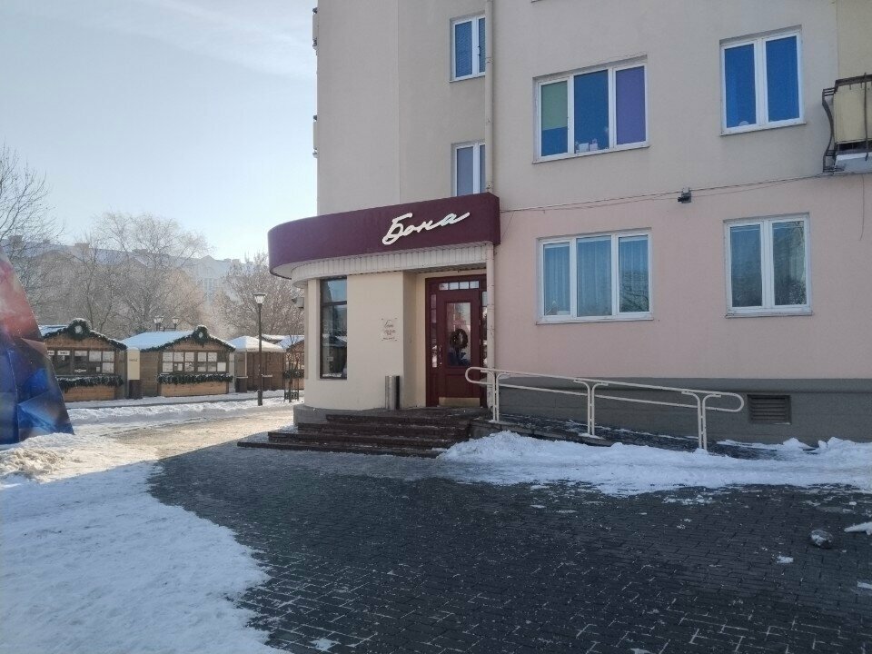 Вход в Бону на углу здания: бордовая вывеска над дверью